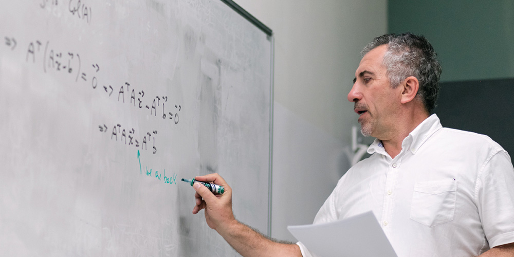 纽约大学柯朗数学、计算与数据科学学院教授在白板上书写数学公式,展示学院拥有世界一流的强大师资力量和研究氛围
