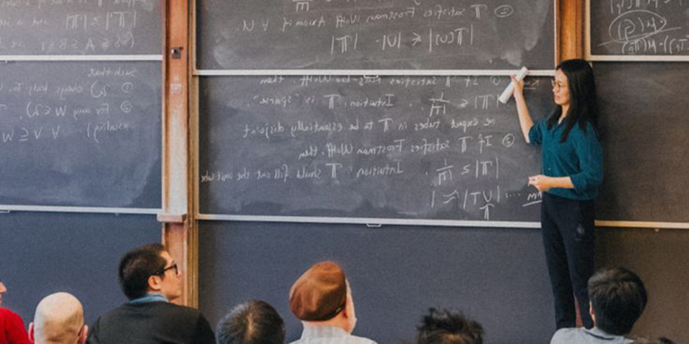 纽约大学柯朗数学、计算与数据科学学院数学硕士课堂教学现场,副教授王虹在黑板前讲授抽象代数与理论数学知识,吸引众多研究生旁听,彰显学院强大科研与教学实力